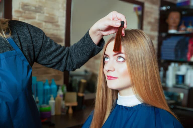 Barber shows to the girl the chosen hair color.